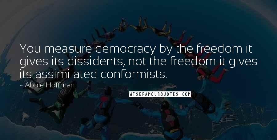 Abbie Hoffman Quotes: You measure democracy by the freedom it gives its dissidents, not the freedom it gives its assimilated conformists.