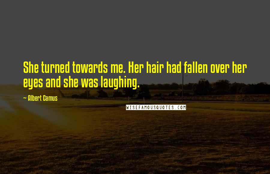 Albert Camus Quotes: She turned towards me. Her hair had fallen over her eyes and she was laughing.