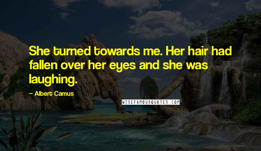 Albert Camus Quotes: She turned towards me. Her hair had fallen over her eyes and she was laughing.