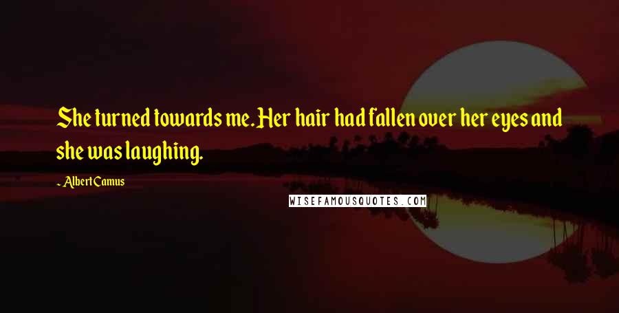 Albert Camus Quotes: She turned towards me. Her hair had fallen over her eyes and she was laughing.