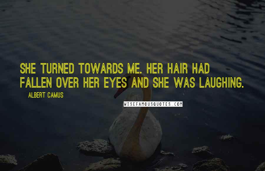 Albert Camus Quotes: She turned towards me. Her hair had fallen over her eyes and she was laughing.