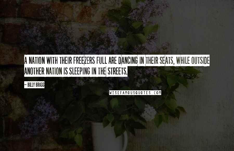 Billy Bragg Quotes: A nation with their freezers full are dancing in their seats, while outside another nation is sleeping in the streets.
