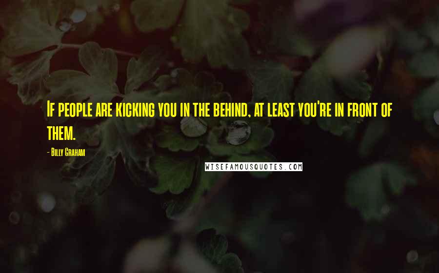 Billy Graham Quotes: If people are kicking you in the behind, at least you're in front of them.