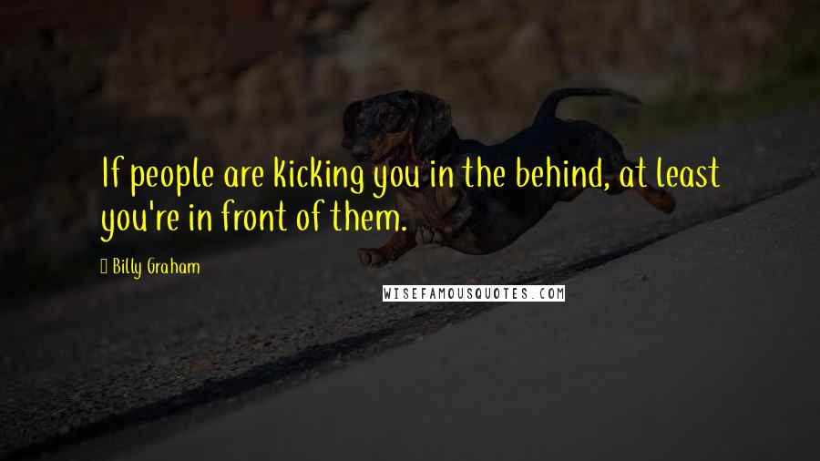 Billy Graham Quotes: If people are kicking you in the behind, at least you're in front of them.