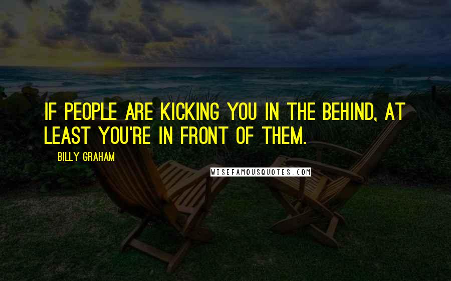 Billy Graham Quotes: If people are kicking you in the behind, at least you're in front of them.