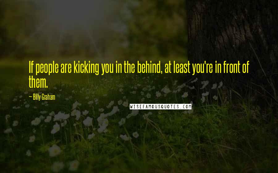 Billy Graham Quotes: If people are kicking you in the behind, at least you're in front of them.