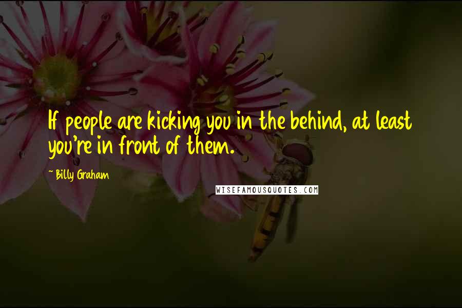 Billy Graham Quotes: If people are kicking you in the behind, at least you're in front of them.