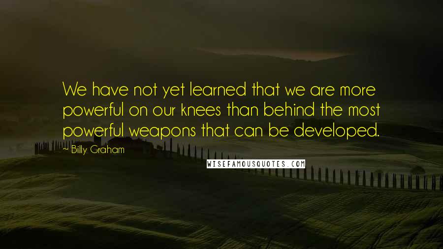 Billy Graham Quotes: We have not yet learned that we are more powerful on our knees than behind the most powerful weapons that can be developed.