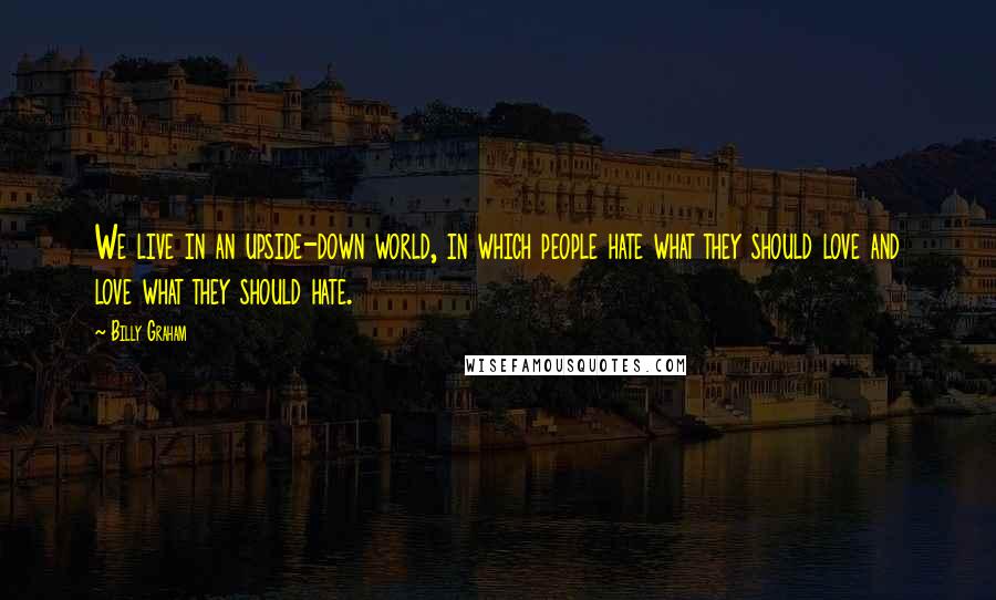 Billy Graham Quotes: We live in an upside-down world, in which people hate what they should love and love what they should hate.