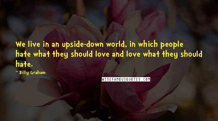 Billy Graham Quotes: We live in an upside-down world, in which people hate what they should love and love what they should hate.