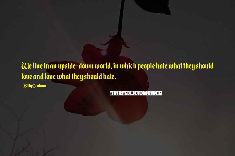 Billy Graham Quotes: We live in an upside-down world, in which people hate what they should love and love what they should hate.