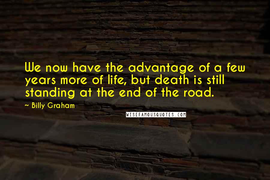 Billy Graham Quotes: We now have the advantage of a few years more of life, but death is still standing at the end of the road.