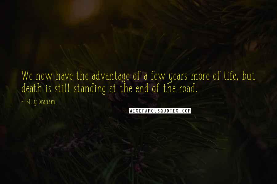 Billy Graham Quotes: We now have the advantage of a few years more of life, but death is still standing at the end of the road.