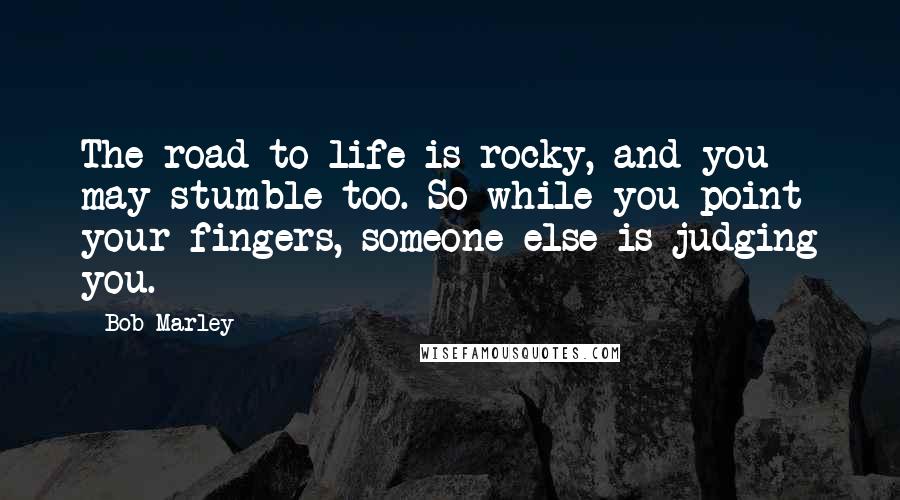 Bob Marley Quotes: The road to life is rocky, and you may stumble too. So while you point your fingers, someone else is judging you.
