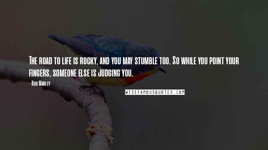 Bob Marley Quotes: The road to life is rocky, and you may stumble too. So while you point your fingers, someone else is judging you.
