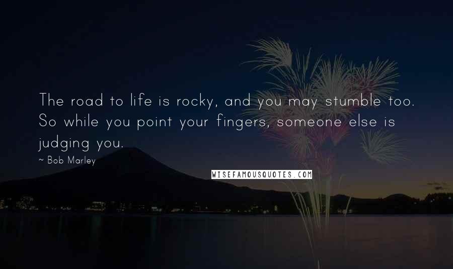 Bob Marley Quotes: The road to life is rocky, and you may stumble too. So while you point your fingers, someone else is judging you.