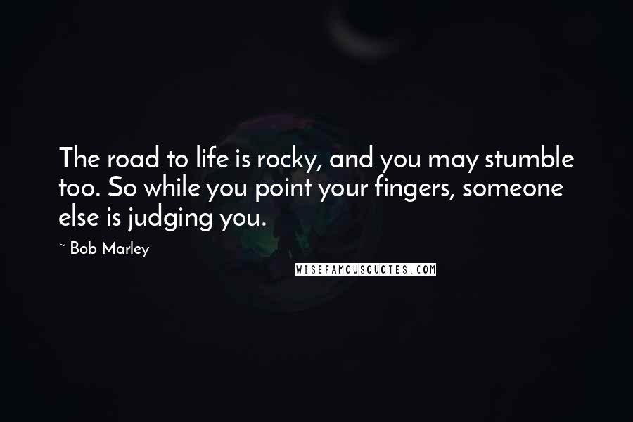 Bob Marley Quotes: The road to life is rocky, and you may stumble too. So while you point your fingers, someone else is judging you.