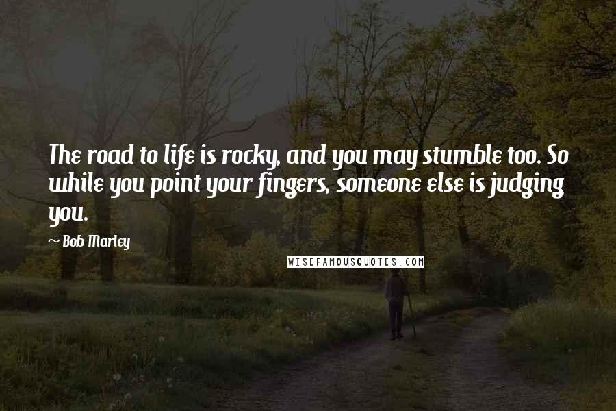 Bob Marley Quotes: The road to life is rocky, and you may stumble too. So while you point your fingers, someone else is judging you.