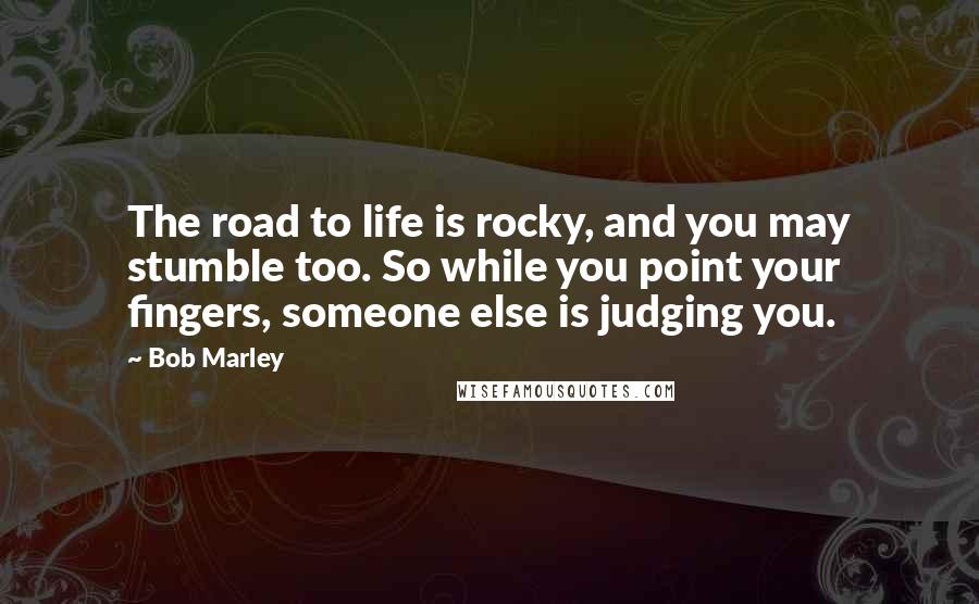 Bob Marley Quotes: The road to life is rocky, and you may stumble too. So while you point your fingers, someone else is judging you.
