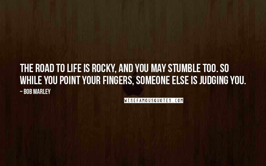 Bob Marley Quotes: The road to life is rocky, and you may stumble too. So while you point your fingers, someone else is judging you.