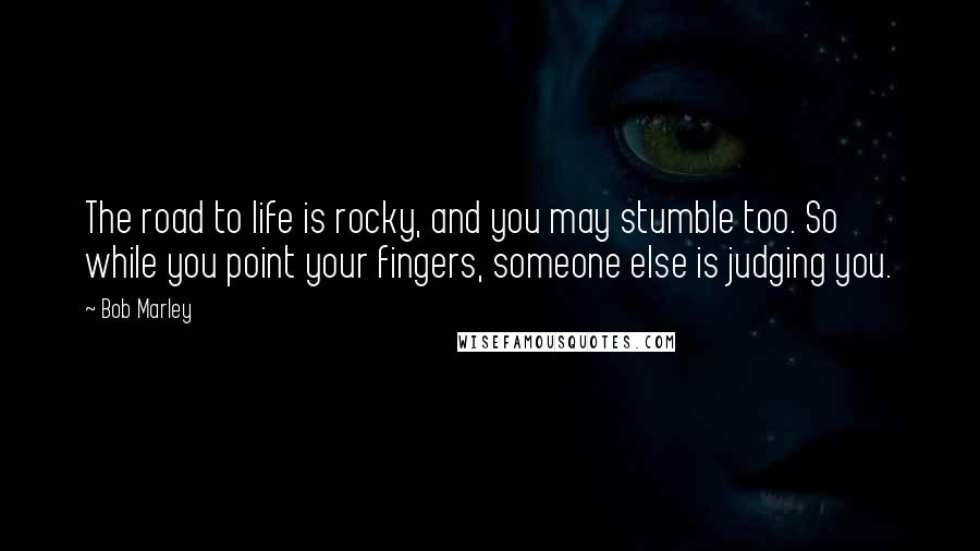 Bob Marley Quotes: The road to life is rocky, and you may stumble too. So while you point your fingers, someone else is judging you.