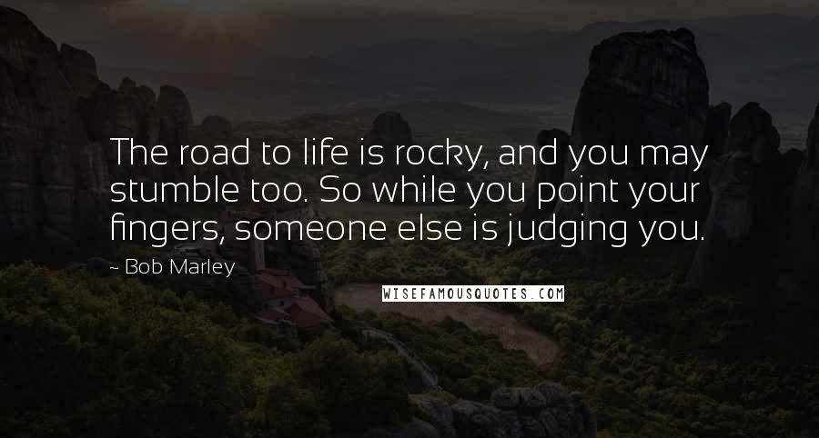Bob Marley Quotes: The road to life is rocky, and you may stumble too. So while you point your fingers, someone else is judging you.