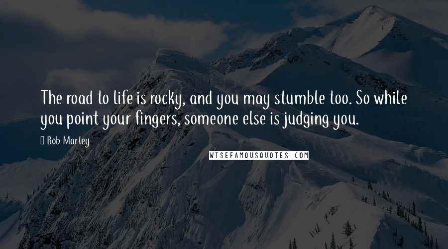 Bob Marley Quotes: The road to life is rocky, and you may stumble too. So while you point your fingers, someone else is judging you.