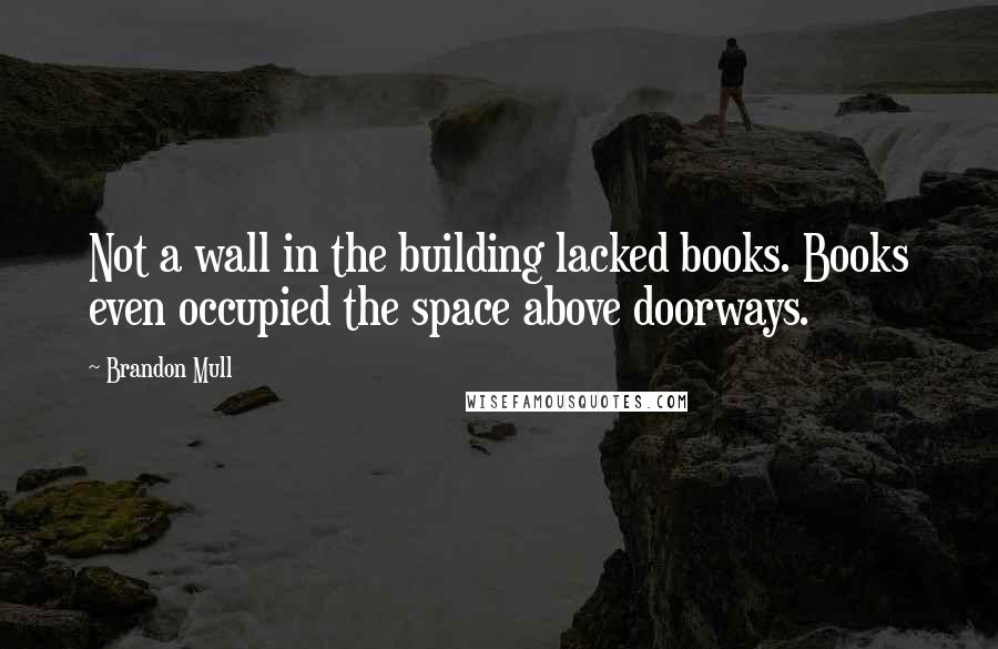Brandon Mull Quotes: Not a wall in the building lacked books. Books even occupied the space above doorways.
