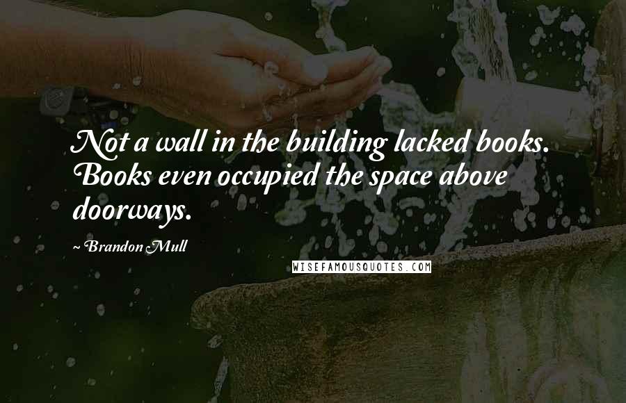 Brandon Mull Quotes: Not a wall in the building lacked books. Books even occupied the space above doorways.