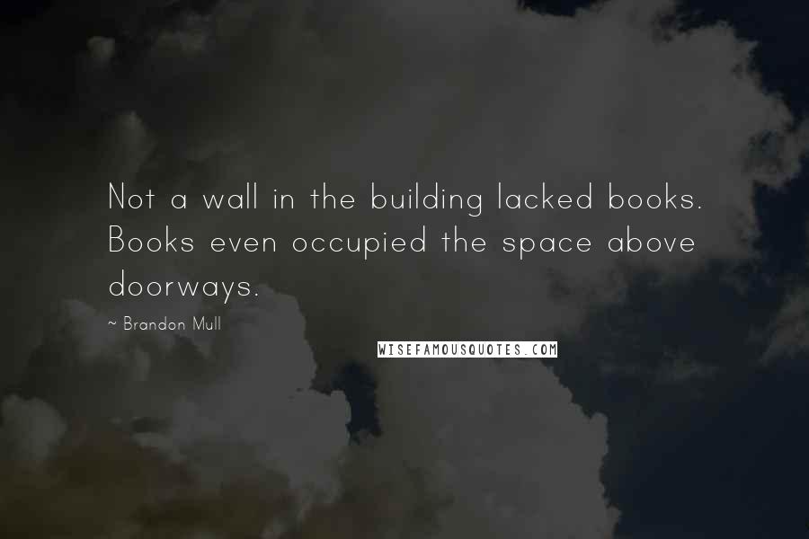 Brandon Mull Quotes: Not a wall in the building lacked books. Books even occupied the space above doorways.