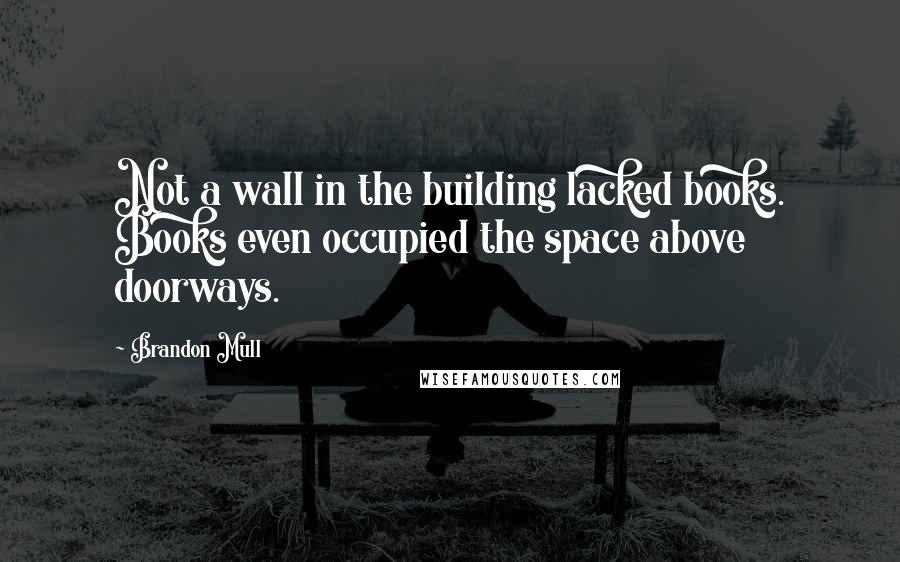 Brandon Mull Quotes: Not a wall in the building lacked books. Books even occupied the space above doorways.