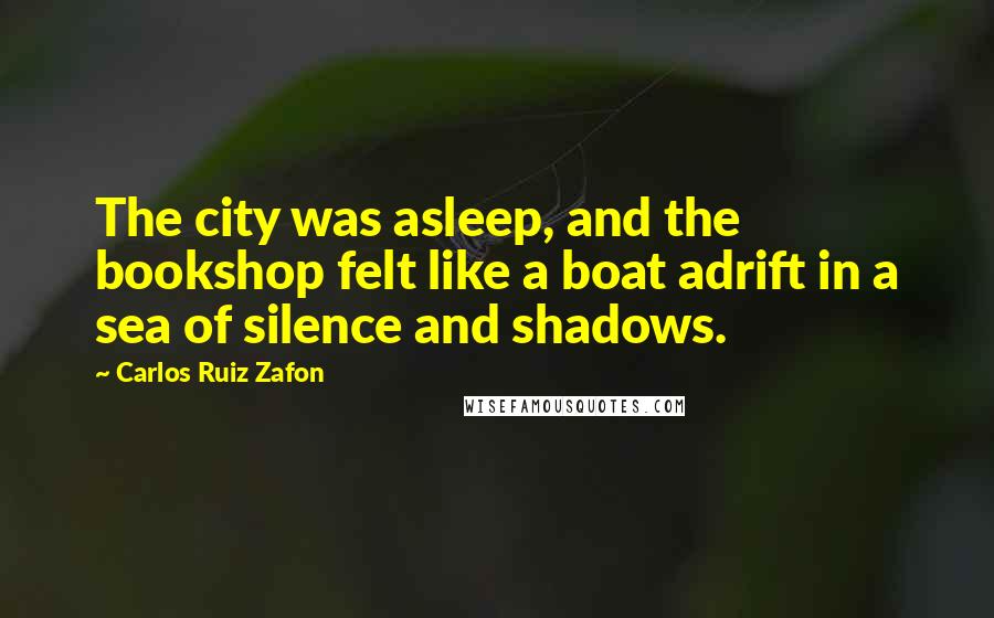 Carlos Ruiz Zafon Quotes: The city was asleep, and the bookshop felt like a boat adrift in a sea of silence and shadows.