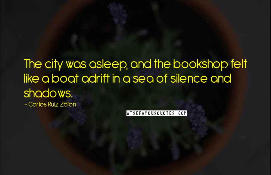 Carlos Ruiz Zafon Quotes: The city was asleep, and the bookshop felt like a boat adrift in a sea of silence and shadows.