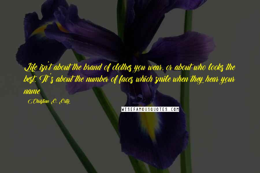 Christian O. Ortiz Quotes: Life isn't about the brand of clothes you wear, or about who looks the best. It's about the number of faces which smile when they hear your name