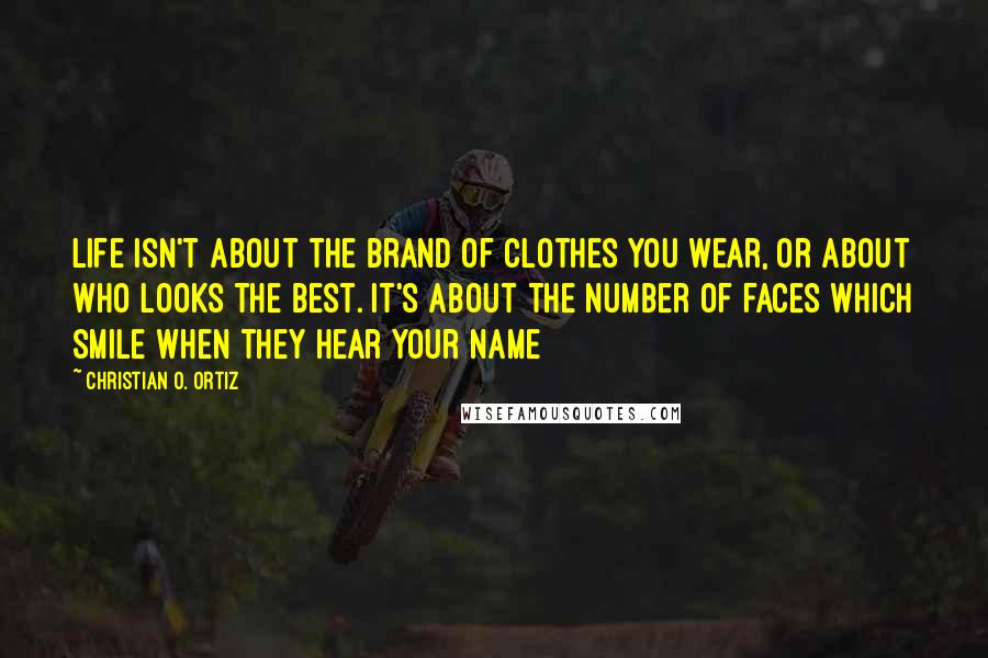 Christian O. Ortiz Quotes: Life isn't about the brand of clothes you wear, or about who looks the best. It's about the number of faces which smile when they hear your name