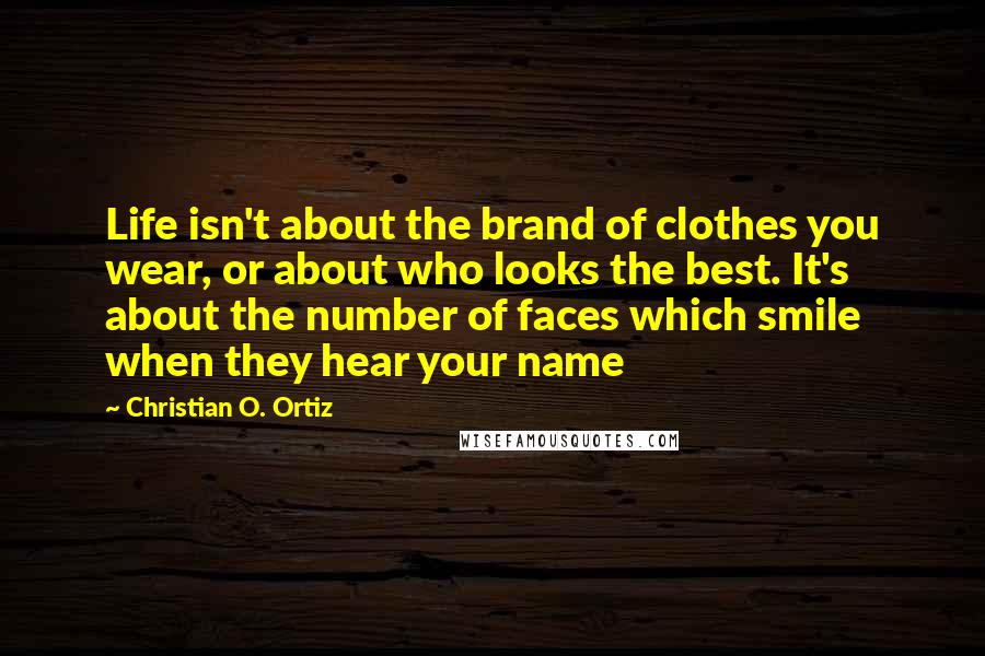 Christian O. Ortiz Quotes: Life isn't about the brand of clothes you wear, or about who looks the best. It's about the number of faces which smile when they hear your name