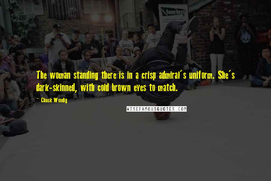 Chuck Wendig Quotes: The woman standing there is in a crisp admiral's uniform. She's dark-skinned, with cold brown eyes to match.