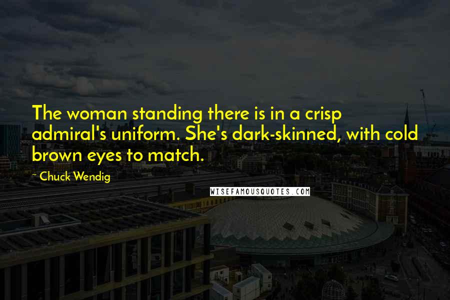 Chuck Wendig Quotes: The woman standing there is in a crisp admiral's uniform. She's dark-skinned, with cold brown eyes to match.