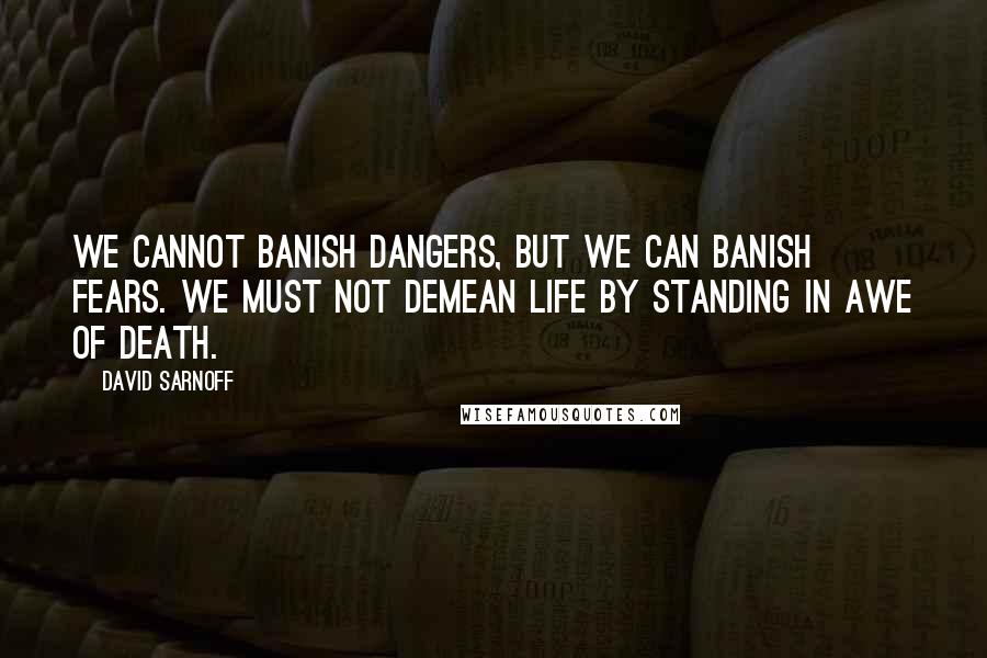 David Sarnoff Quotes: We cannot banish dangers, but we can banish fears. We must not demean life by standing in awe of death.