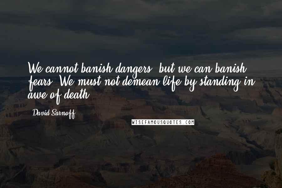David Sarnoff Quotes: We cannot banish dangers, but we can banish fears. We must not demean life by standing in awe of death.