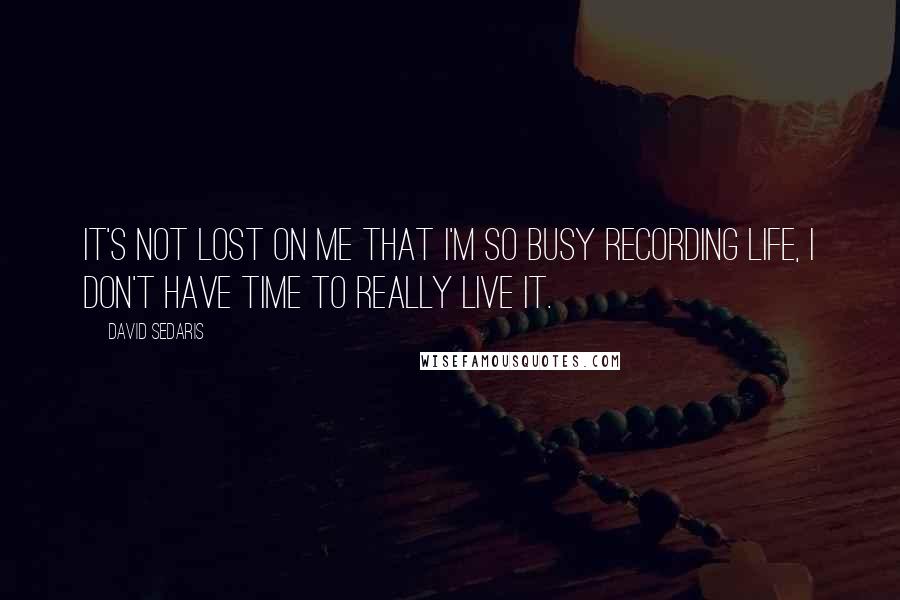 David Sedaris Quotes: It's not lost on me that I'm so busy recording life, I don't have time to really live it.