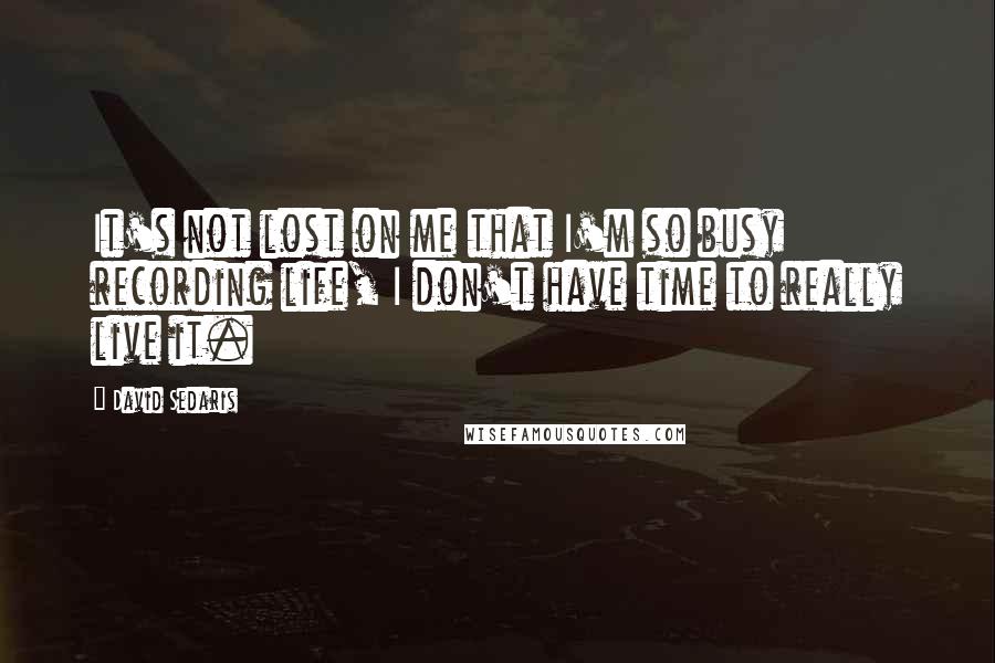 David Sedaris Quotes: It's not lost on me that I'm so busy recording life, I don't have time to really live it.