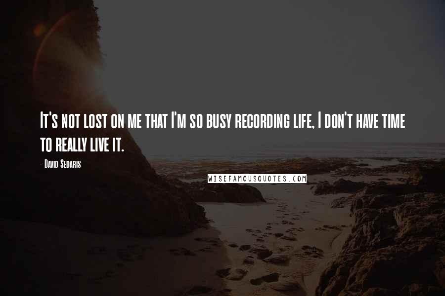 David Sedaris Quotes: It's not lost on me that I'm so busy recording life, I don't have time to really live it.