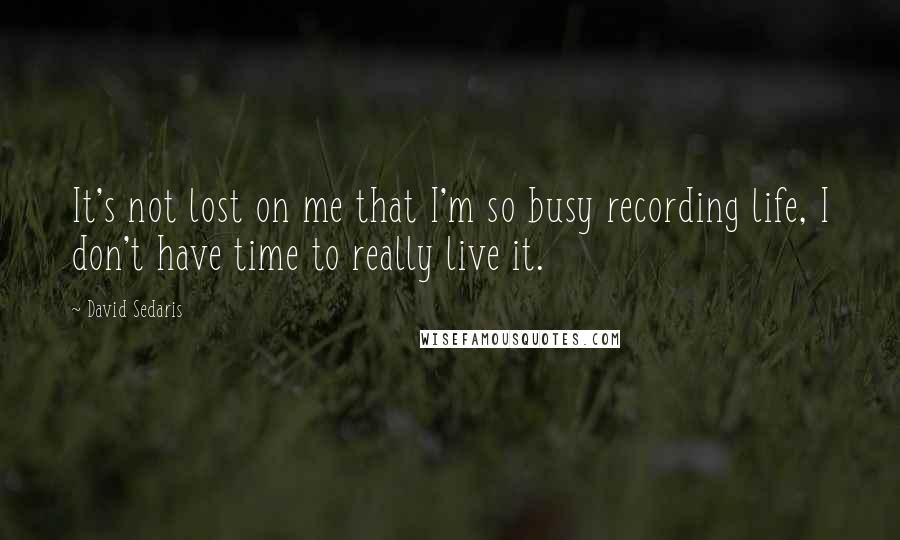 David Sedaris Quotes: It's not lost on me that I'm so busy recording life, I don't have time to really live it.