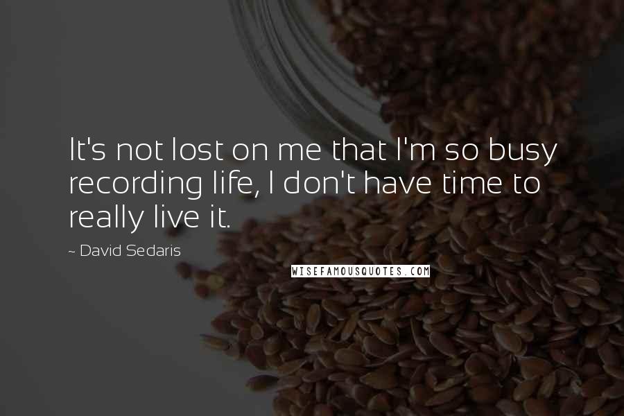 David Sedaris Quotes: It's not lost on me that I'm so busy recording life, I don't have time to really live it.