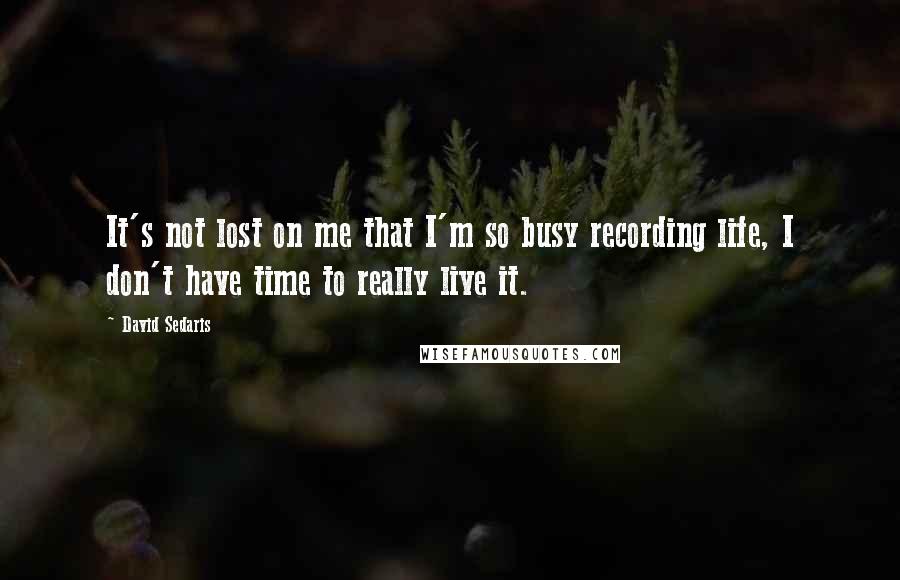 David Sedaris Quotes: It's not lost on me that I'm so busy recording life, I don't have time to really live it.