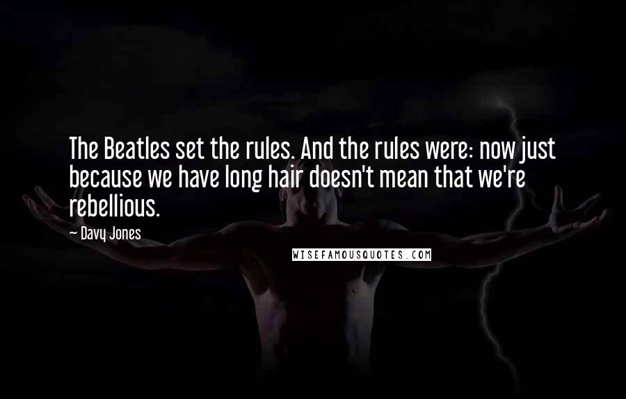 Davy Jones Quotes: The Beatles set the rules. And the rules were: now just because we have long hair doesn't mean that we're rebellious.