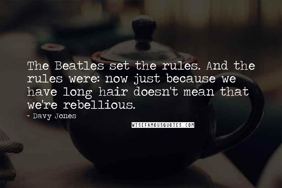 Davy Jones Quotes: The Beatles set the rules. And the rules were: now just because we have long hair doesn't mean that we're rebellious.
