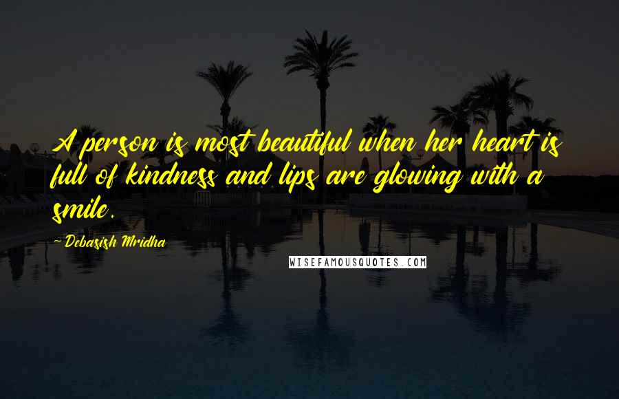 Debasish Mridha Quotes: A person is most beautiful when her heart is full of kindness and lips are glowing with a smile.