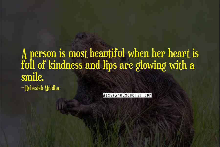 Debasish Mridha Quotes: A person is most beautiful when her heart is full of kindness and lips are glowing with a smile.